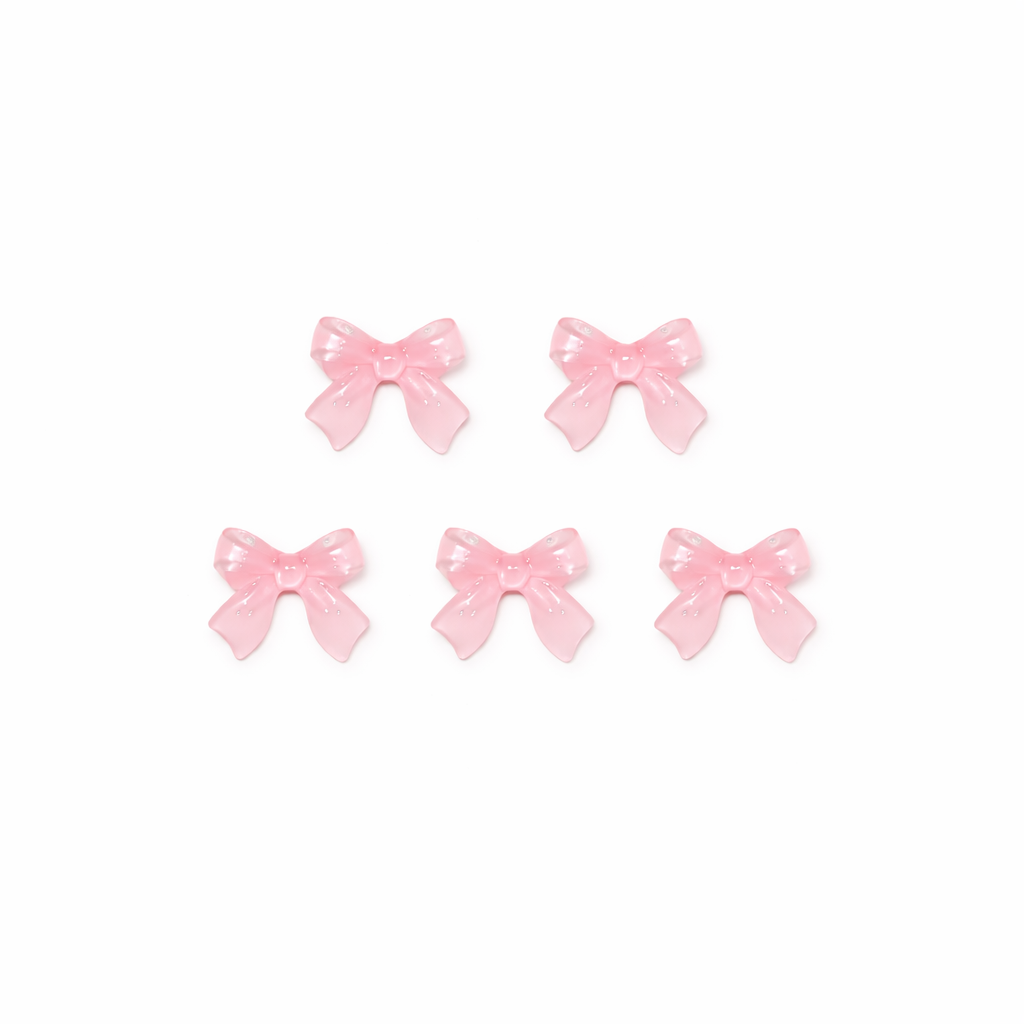 Set of five pink bow-shaped nail charms on a white background